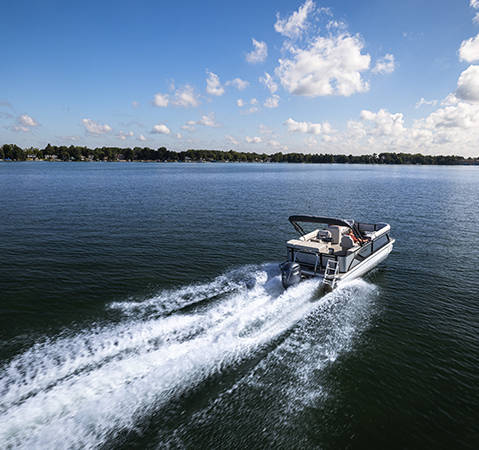 Overhead view of a Godfrey Sweetwater Special Edition pontoon speeding across a lake. 