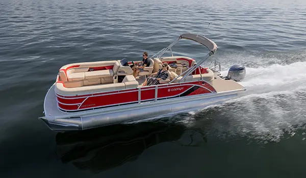 Side profile of a Godfrey Sweetwater Split Bench pontoon boat cruising across a lake.