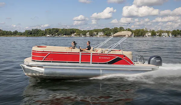 Side profile of a couple relaxing on a Godfrey Sweetwater Split Bench pontoon boat.