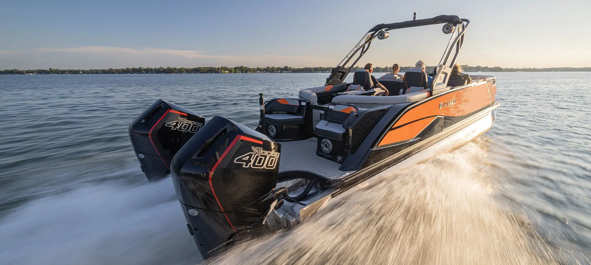 Godfrey XP Tritoon boat speeding across a lake with its twin engines.