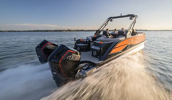 Godfrey XP Tritoon boat speeding across a lake with its twin engines.
