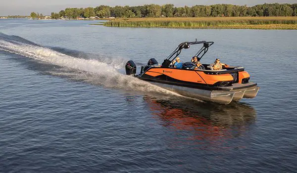 An orange Godfrey XP Tritoon boat cruising on a lake with 4 passengers on board.