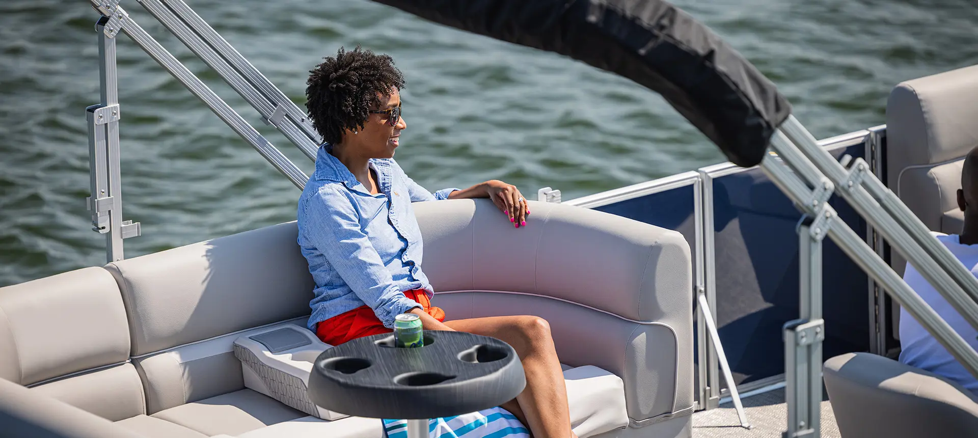 Woman sitting on the stern seat on a Godfrey Xperience Cruise pontoon boat.