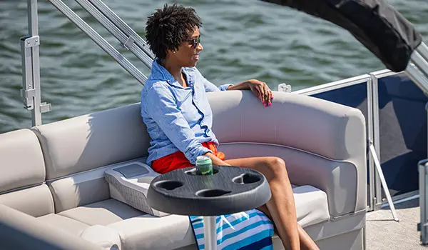 Woman sitting on the stern seat on a Godfrey Xperience Cruise pontoon boat.
