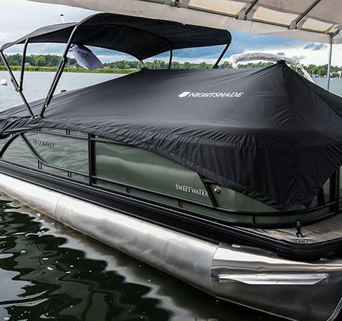 Godfrey Sweetwater pontoon boat protected by a black Nightshade boat cover.
