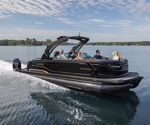 Passengers enjoying a ride on a luxury black Godfrey Sanpan Pontoon boat as it speeds across a lake.