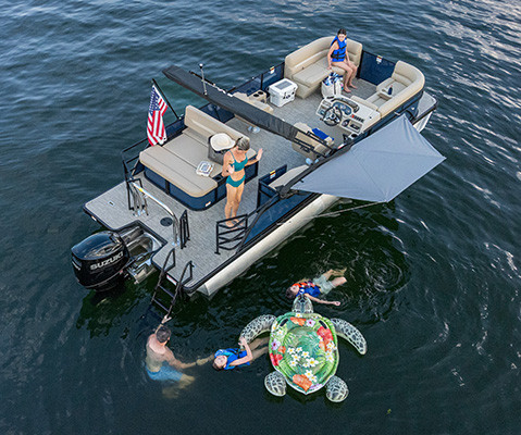 Overhead view of a parked Godfrey Pontoon Boat with shade attached to side with toolless boat accessory attachment system. 