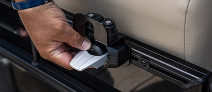 Man sliding toolless accessory system into rail channel along pontoon's integrated rail system. 