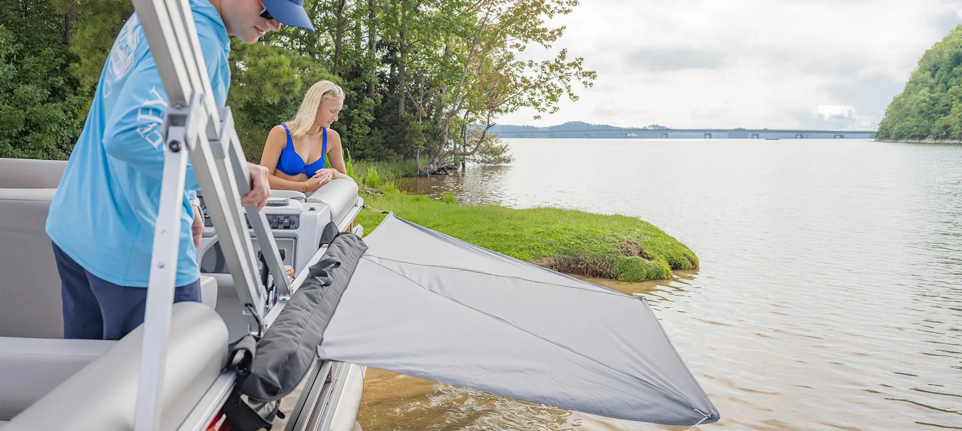 Sun shade attached to the side of a pontoon boat using a toolless boat accessory attachment system.