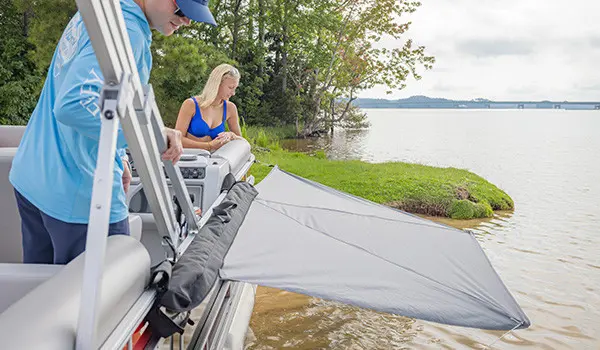 Sun shade attached to the side of a pontoon boat using a toolless boat accessory attachment system.