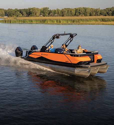 Family speeds across lake on a Godfrey Pontoon Boat. 