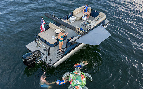 Godfrey pontoon boat parked on lake with Click & Cruise accessories attached. 