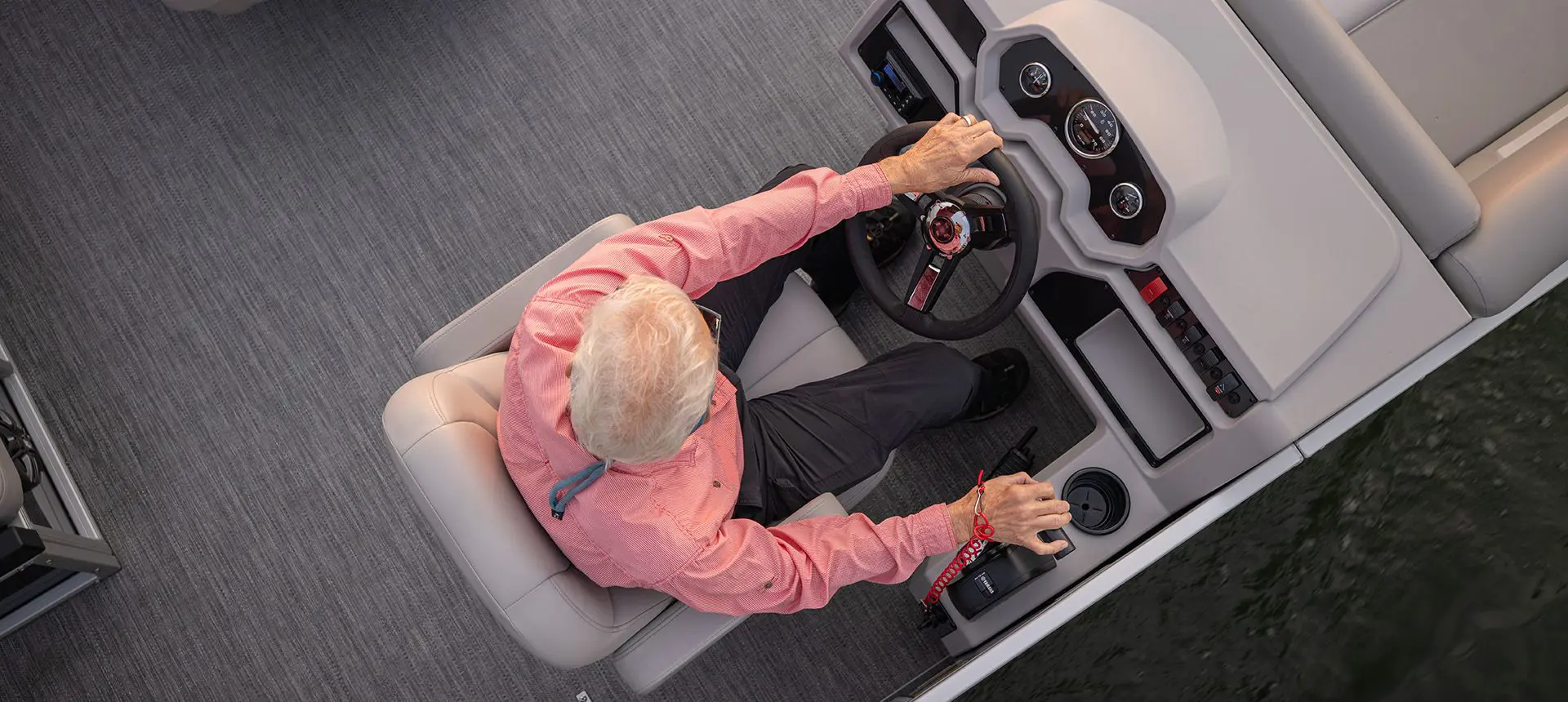Aerial view of a man at the helm of a Godfrey Xperience pontoon boat.