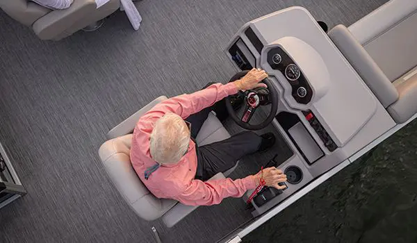 Aerial view of a man at the helm of a Godfrey Xperience pontoon boat.