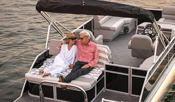 A couple relaxing closely on the stern of a Godfrey Xperience pontoon boat.
