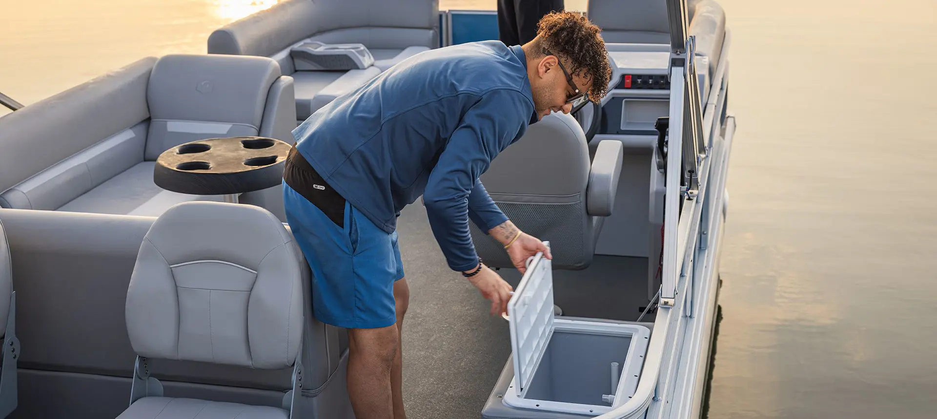 Man opening the livewell on a Godfrey Xperience pontoon boat.