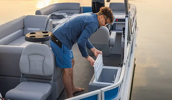 Man opening the livewell on a Godfrey Xperience pontoon boat.
