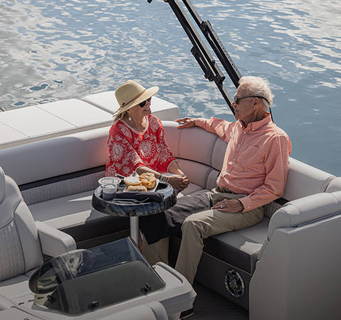 A couple relaxing on a Godfrey pontoon boat with the Cruise layout.