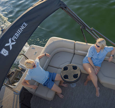 A couple relaxing on a Godfrey pontoon boat with the Cruise P-Seating (CP) layout.
