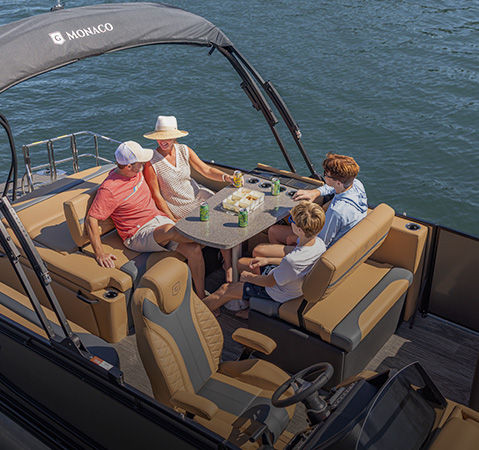 4 people enjoying a snack and a beverage at the Mid-Table on a Godfrey pontoon boat with a Mid-Table Flip (MTF) layout.