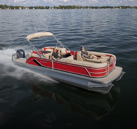 A Godfrey pontoon boat with a Split Bench  - Co-Captain's Chairs (SBC) layout cruising across a lake.