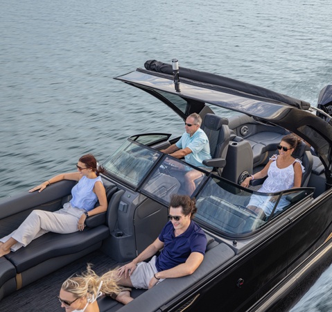 2 people in the co-captain's chair behind a windshield of a Godfrey pontoon boat with Split Bench layout.