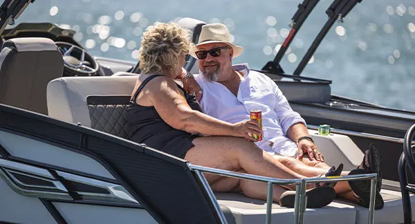 A couple enjoying each others presence on the swingback seat of a Godfrey AquaPatio pontoon boat.