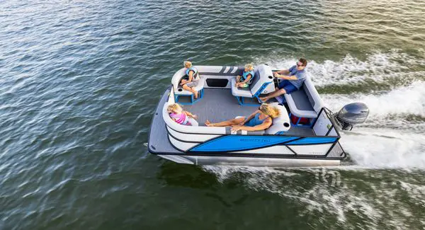 A family of 5 cruising a lake on a Godfrey Mighty G pontoon boat.