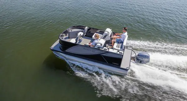 Aerial view of a Godfrey Mighty G pontoon boat driving out to a fishing spot on a lake.