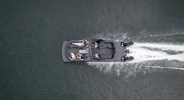 Aerial view of a Godfrey Sanpan pontoon boat speeding across a lake.