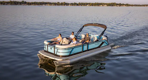 Four people cruising the lake on a Godfrey Sweetwater pontoon boat.