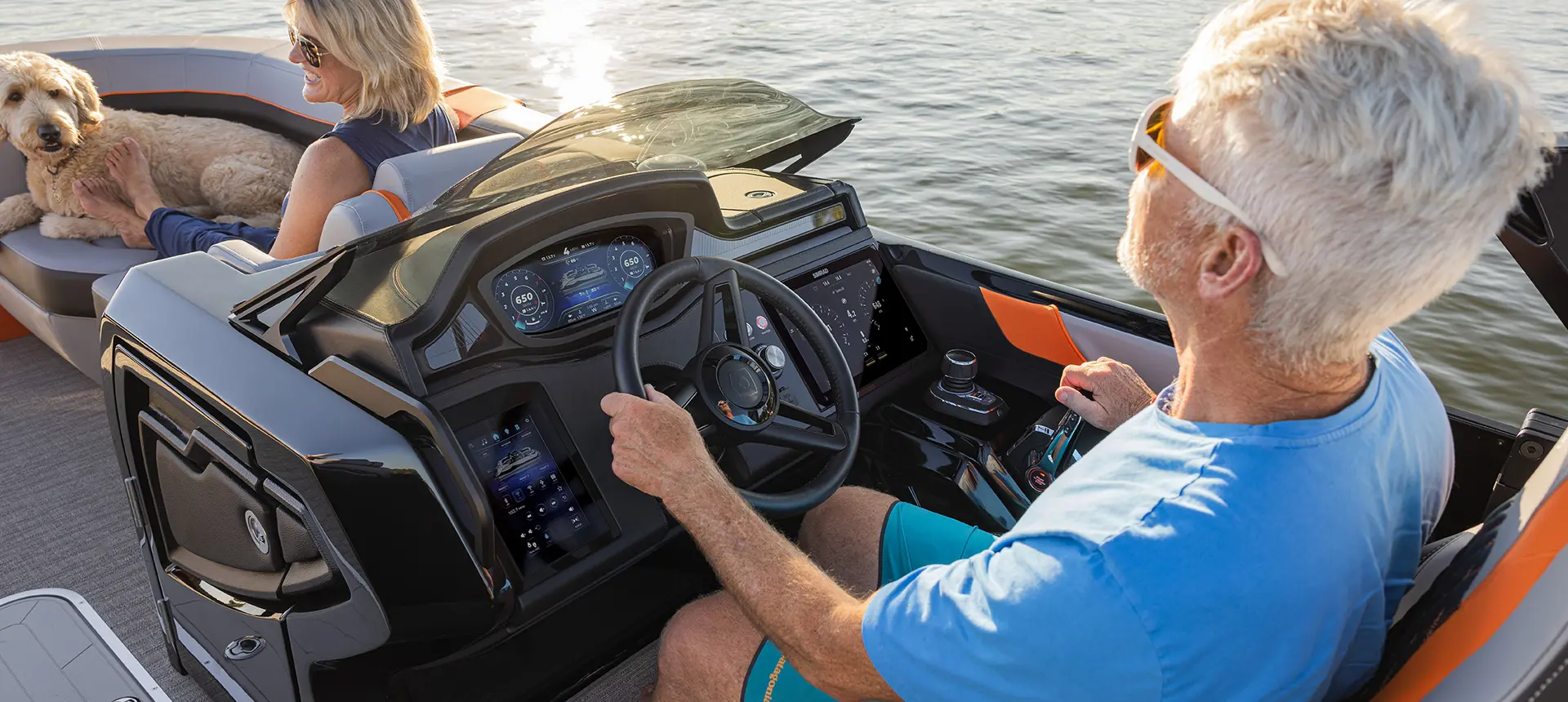 Over-the-shoulder view of a man sitting at the dual digital helm on his Godfrey XP tritoon boat.