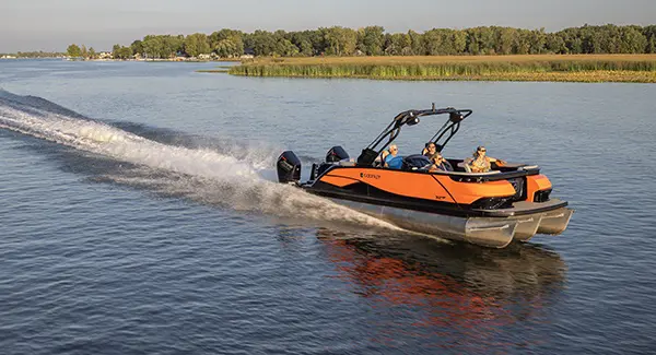 4 people cruising the lake on a Godfrey XP tritoon boat.