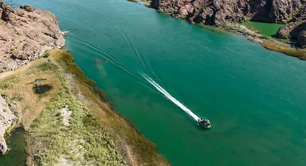 Aerial view of a Godfrey XP tritoon boat driving through a lagoon.