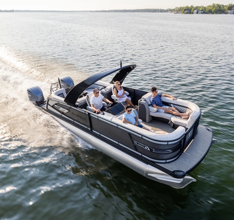 4 people cruising a lake on a Godfrey AquaPatio pontoon boat.
