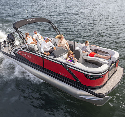 A Godfrey pontoon boat with the co-captain seating option layout cruising across a lake.