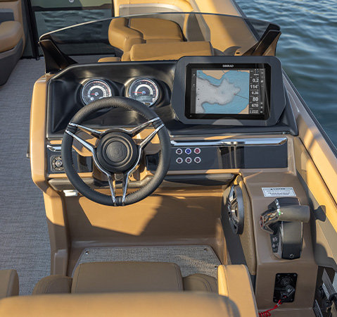 Godfrey AquaPatio helm featuring a steering wheel, analog gauges, controls and a SIMRAD navigation display.