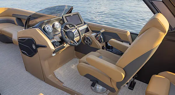 Closeup of the helm and captain's chair on a Godfrey AquaPatio pontoon boat.