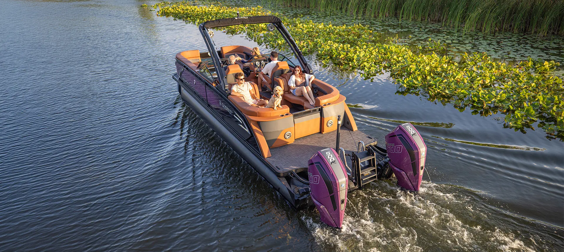 People enjoying a cruise on a Godfrey AquaPatio pontoon boat with twin engines.