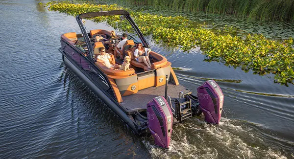 People enjoying a cruise on a Godfrey AquaPatio pontoon boat with twin engines.