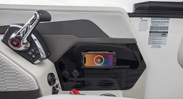 Wireless phone charger at the helm of a Godfrey AquaPatio pontoon boat.