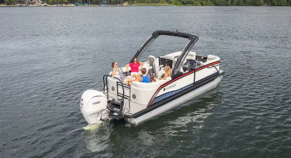 4 people sitting on the stern of a Godfrey Monaco pontoon boat.