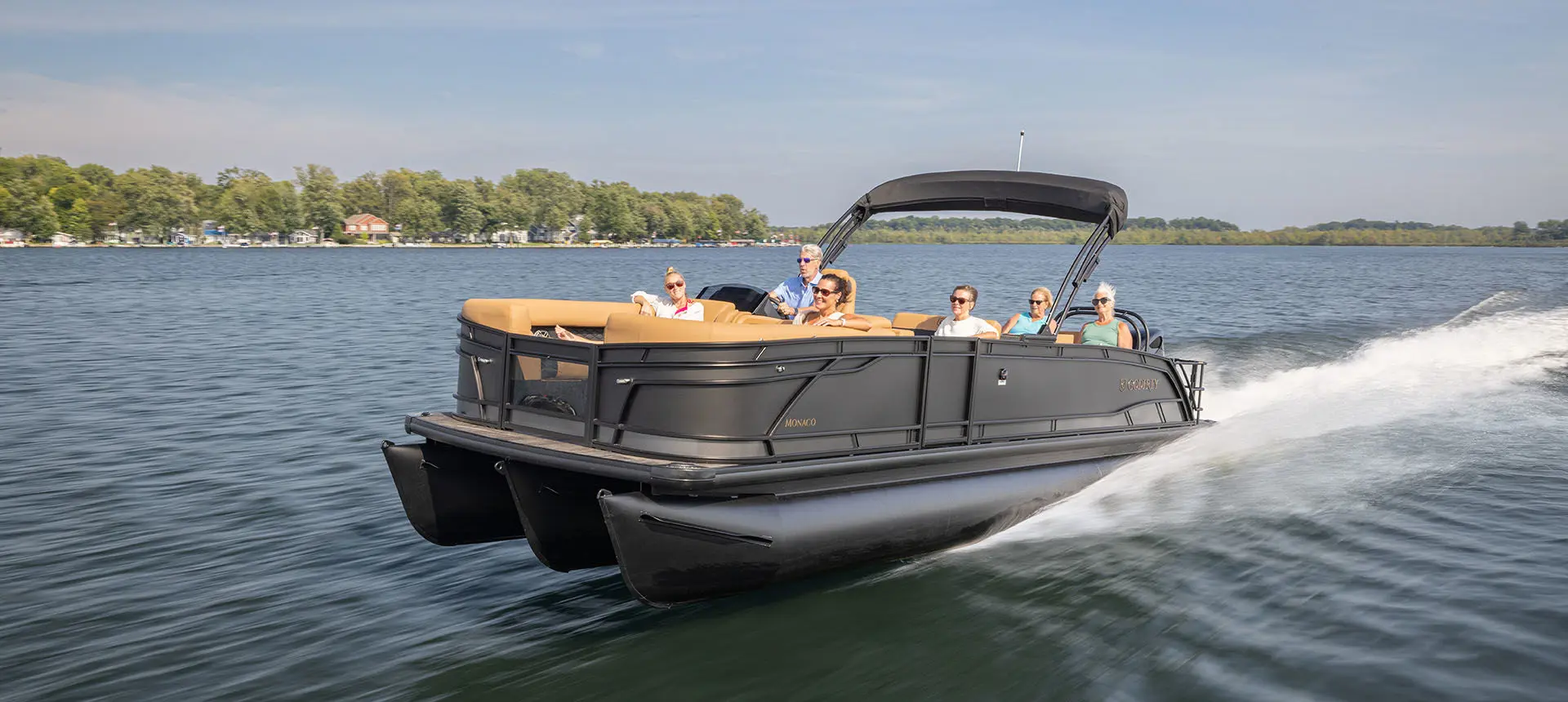 6 people crusing the lake on a Godfrey Monaco pontoon boat.