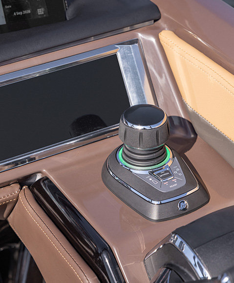A close-up of a joystick control on the helm of a Godfrey Sanpan pontoon boat