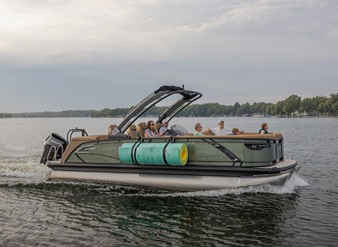 Side-view of a Godfrey pontoon boat with a rolled-up floating water mat attached to the side with toolless boat accessory attachment system. 