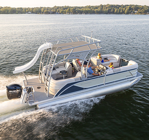 Godfrey Sweetwater pontoon boat with an upper deck and waterslide carrying passengers across a lake.