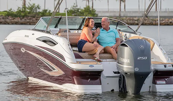 couple enjoying the lake on their black cherry hurricane sundeck 2410 OB deck boat