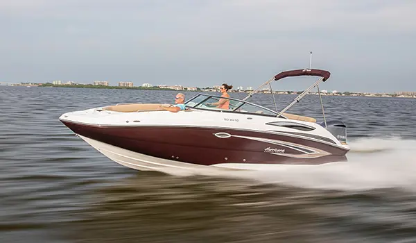 black cherry hurricane sundeck 2410 OB deck boat speeding across a lake
