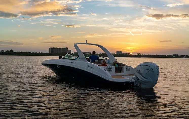 monaco blue hurricane sundeck 2690 OB deck boat floating at sunset