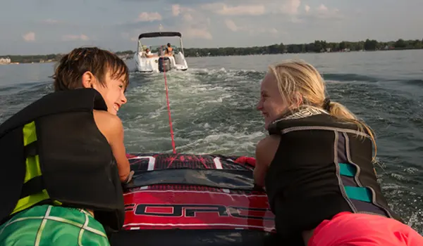 kids tubing behind a hurricane sundeck 2200 DC OB deck boat